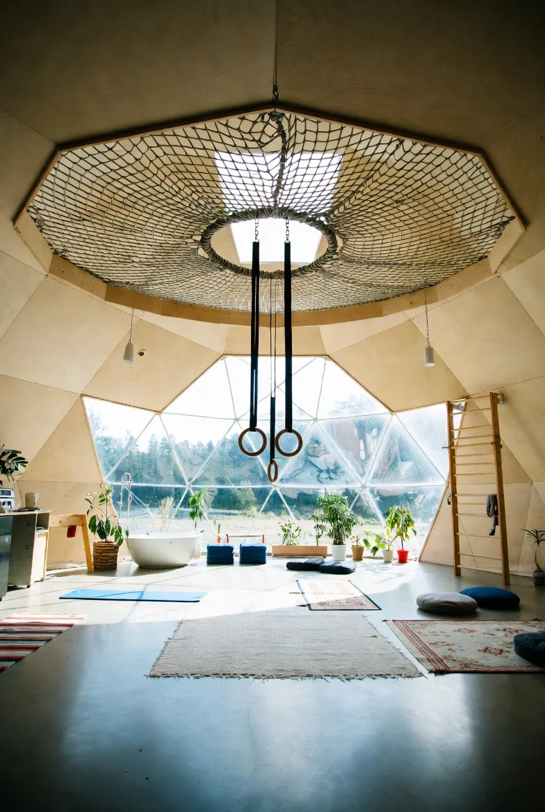 The original dome concept with overhead net, gymnastic rings, plants and a freestanding tub.